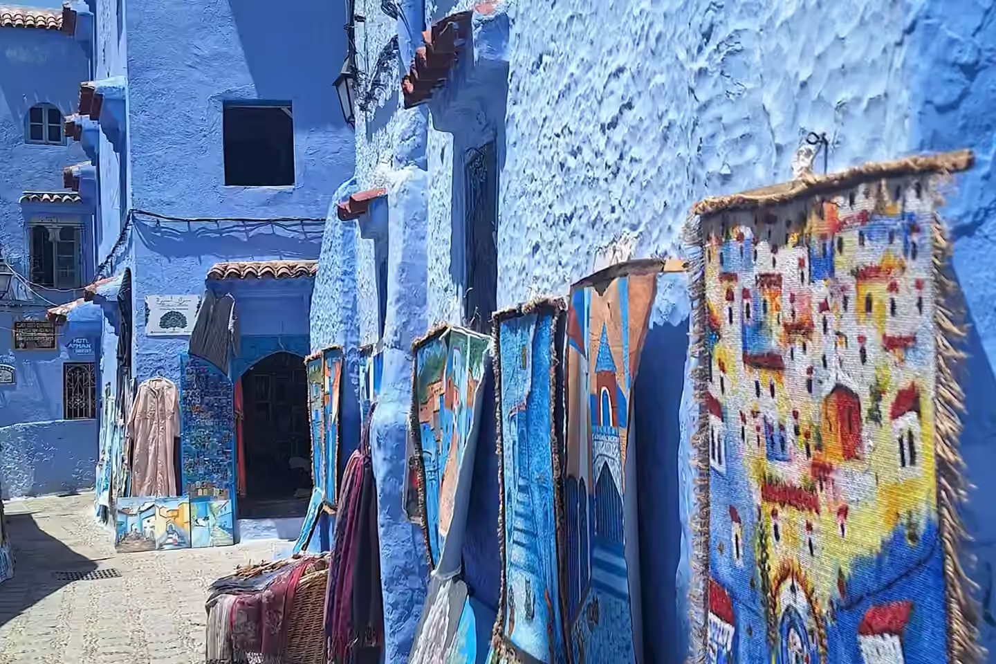 Des tableaux de la ville bleue à vendre sur un mur de Chefchaouen