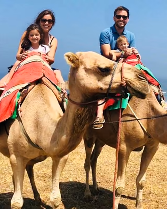 A family on a camel ride on the beach near Asilah