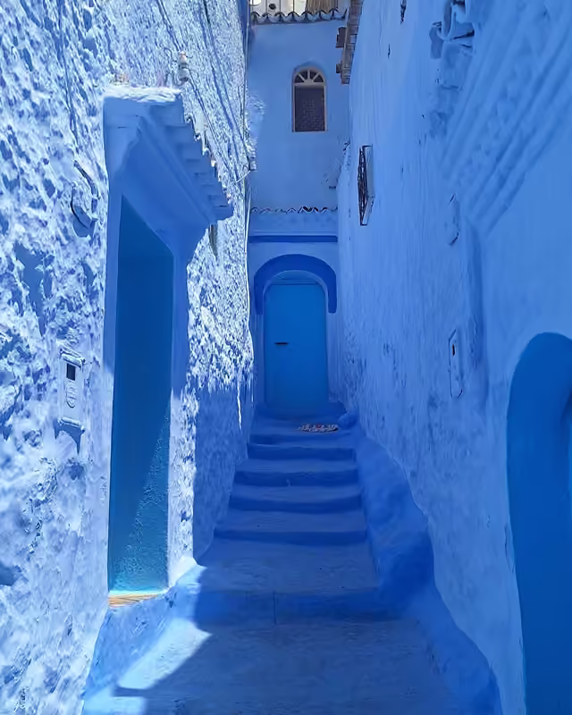 Blue steps and a blue doorway in a Chefchaouen lane