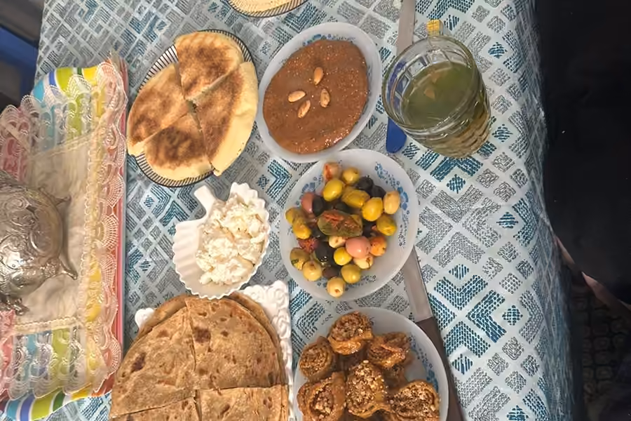 Moroccan breads, olives, honey and mint tea spread on a home table