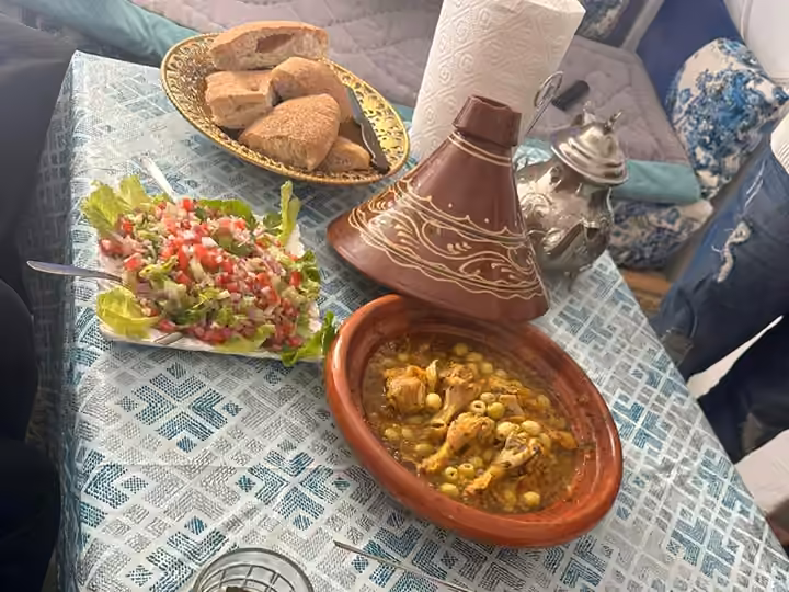 A tagine, a fresh salad and bread on a Moroccan home table