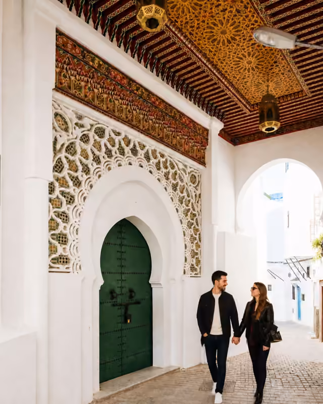 A couple walking past a green door in the Tangier Kasbah