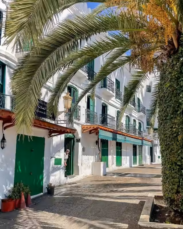A white Andalusian street with green doors in Tetouan