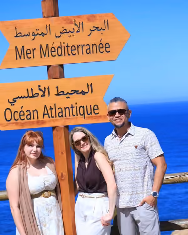 Des voyageurs avec leur guide au panneau du cap Spartel, là où la Méditerranée rencontre l’Atlantique