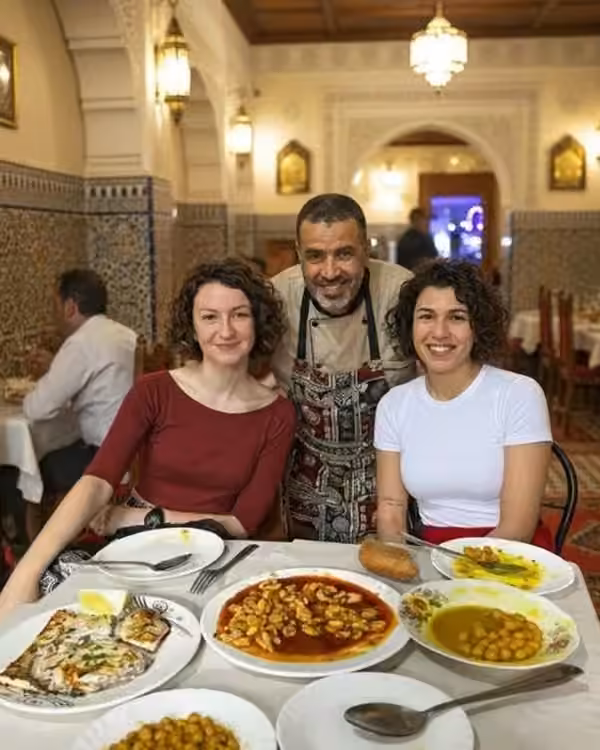Des voyageurs devant une table de plats marocains pendant une visite gourmande à Tanger