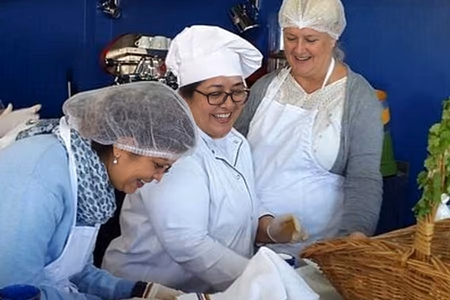 Deux cuisiniers en blanc rient devant des bols d’épices pendant un cours de cuisine