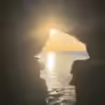 El sol poniente enmarcado por la abertura al mar de las Cuevas de Hércules